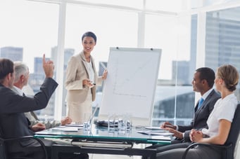 Colleagues asking a question to a businesswoman during a presentation